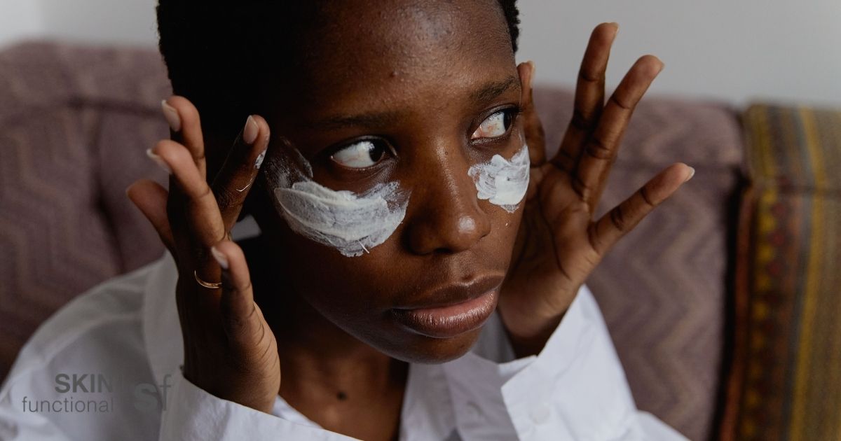 Woman applying a niacinamide and zinc treatment under her eyes, focusing on oily and breakout-prone skin