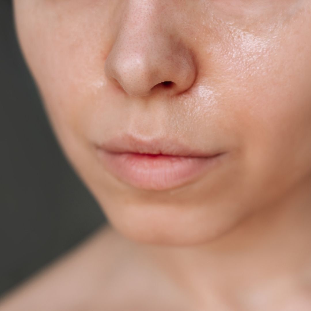 Close-up of a person's face with a neutral expression on a dark background